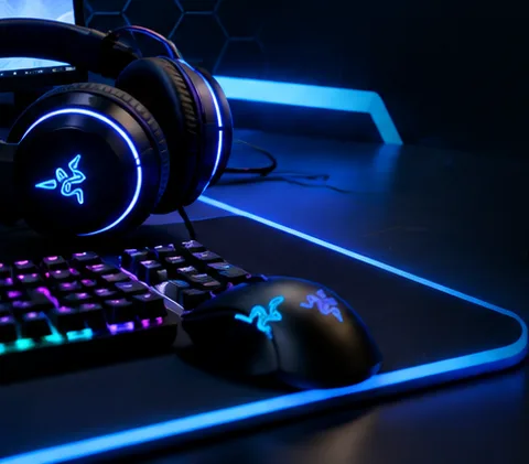 Kufje gaming dhe tastierë mbi një tavolinë të ndriçuar